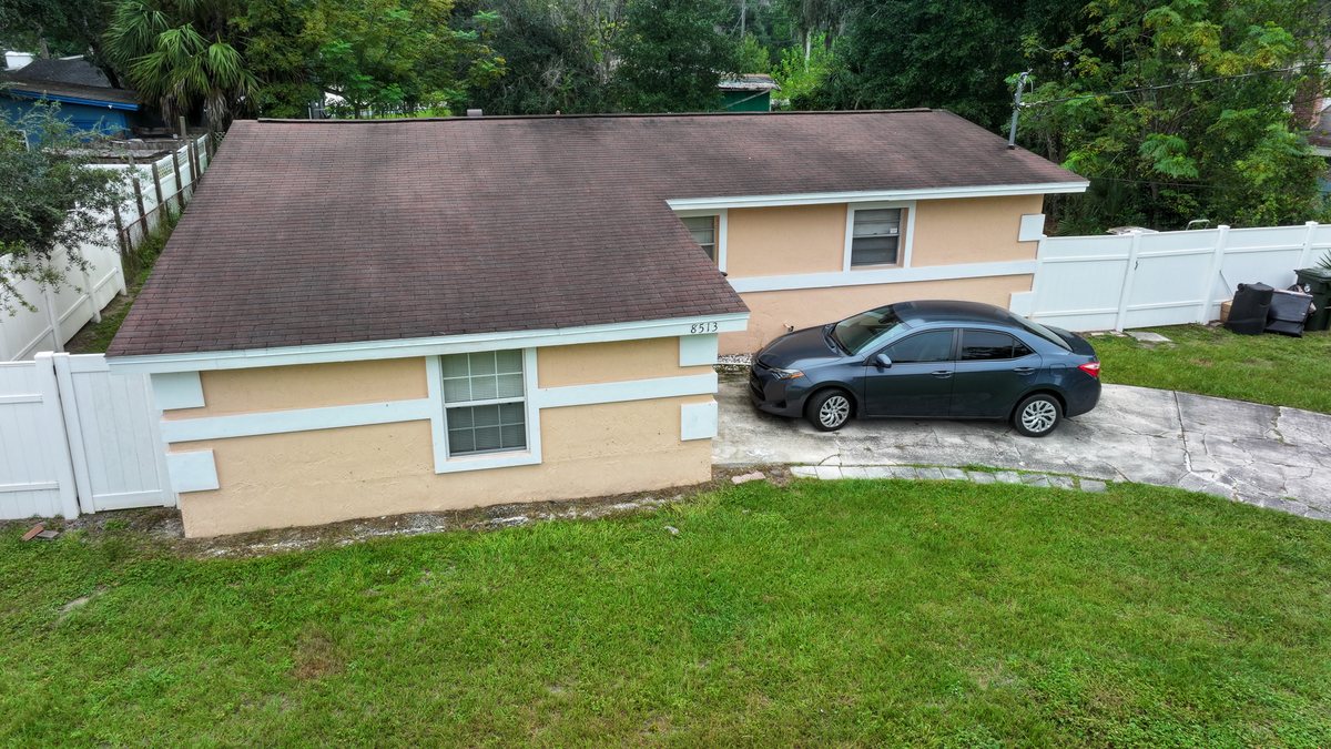 Elevated drone view of a Jacksonville home showing its roof, front elevation, and driveway