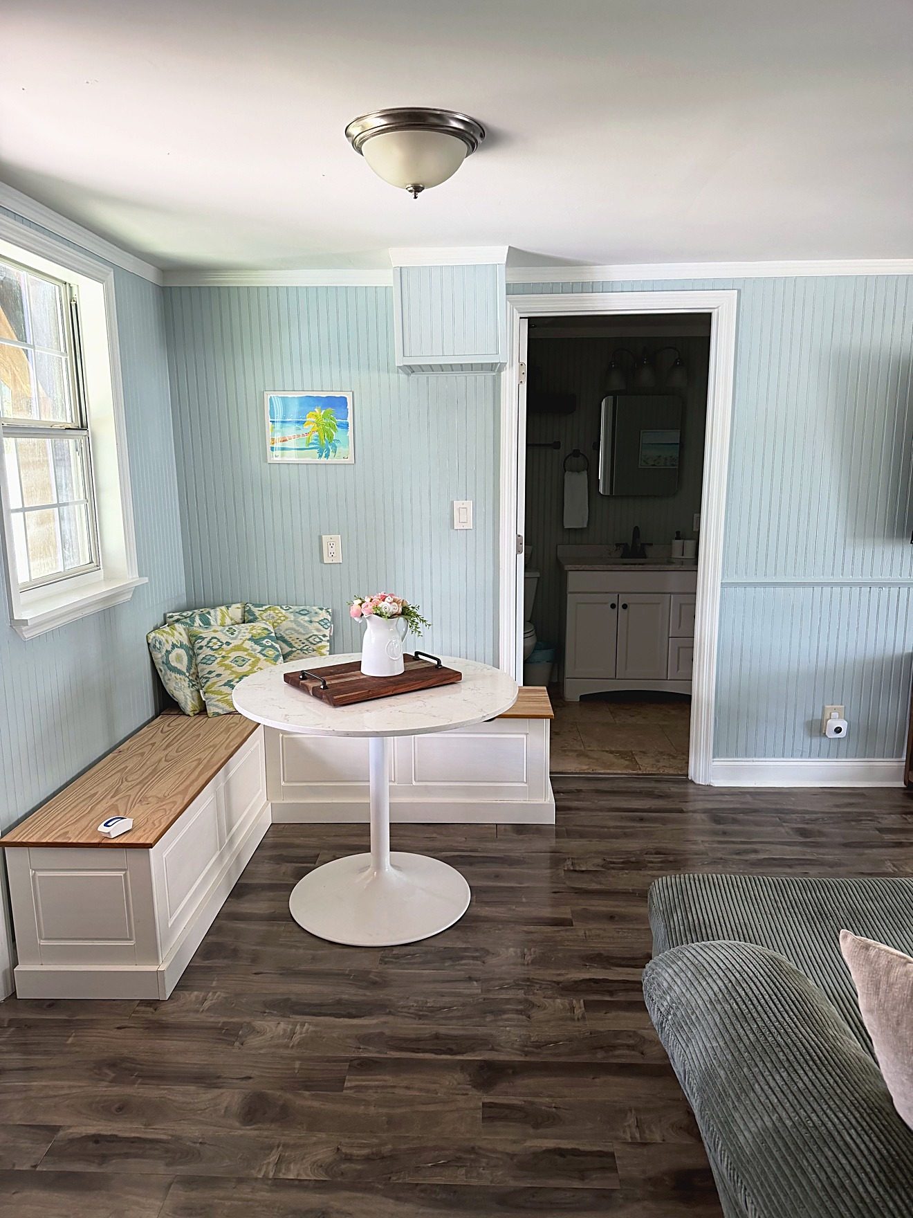 Dining nook with a round white table and built-in bench seating in a coastal rental home