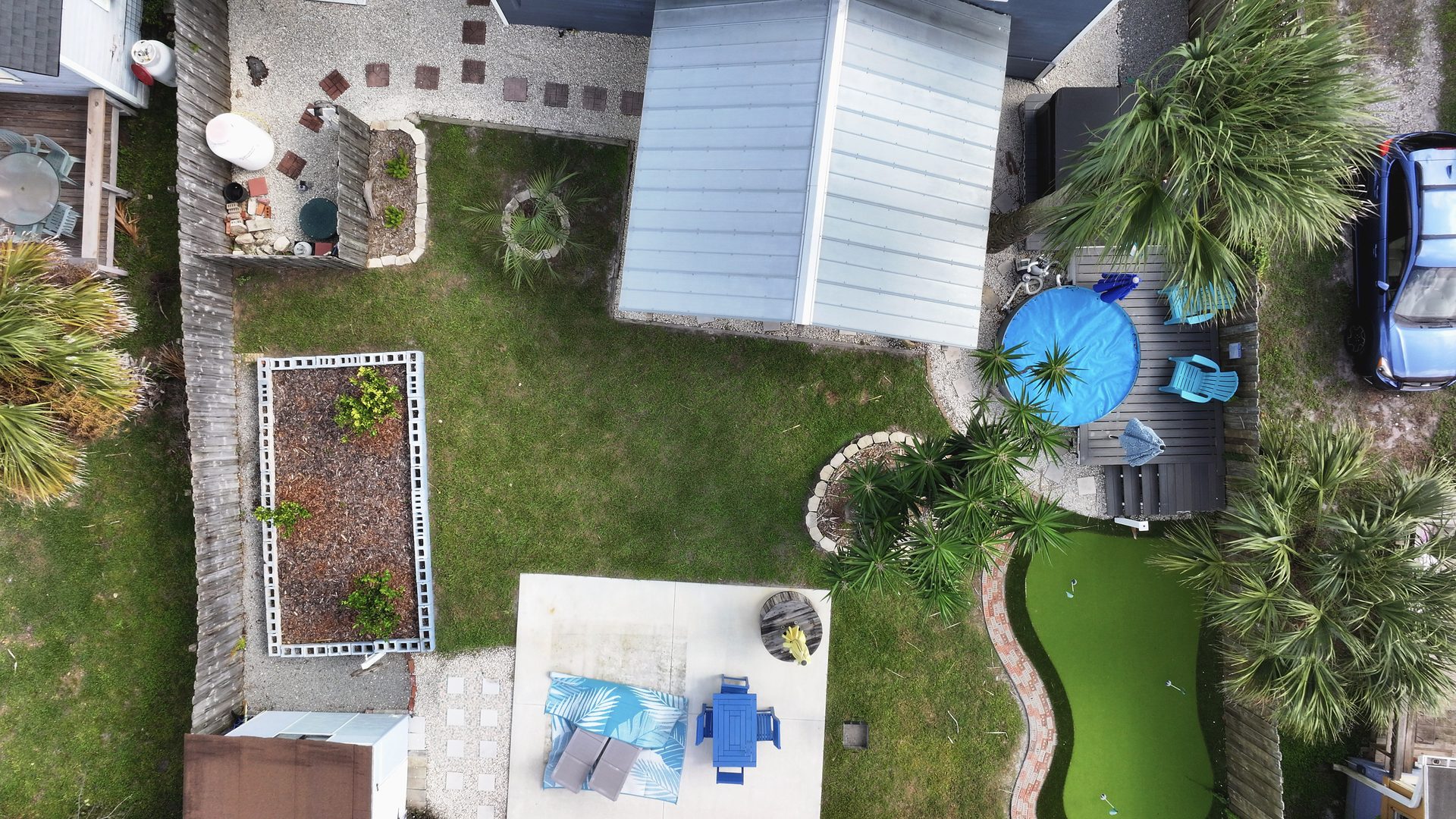 Cleaned top-down drone aerial of a coastal home's backyard, patio, and lot, photographed by Adam Reel Media