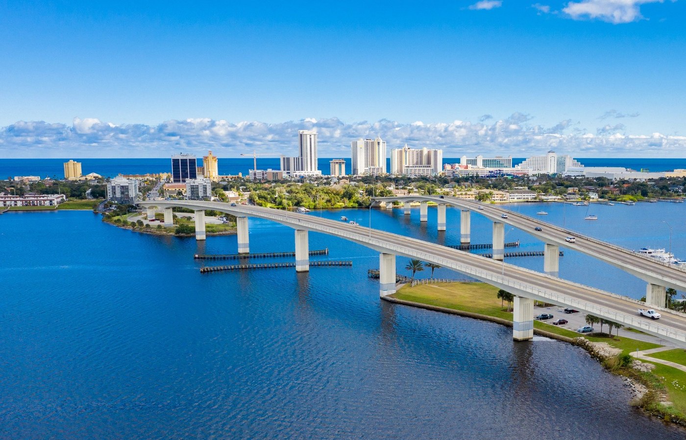 Aerial drone photograph of twin bridges crossing the Intracoastal Waterway toward a Florida beach skyline
